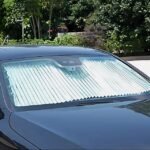 Car sunshade curtain installed on rear windshield for sun protection.