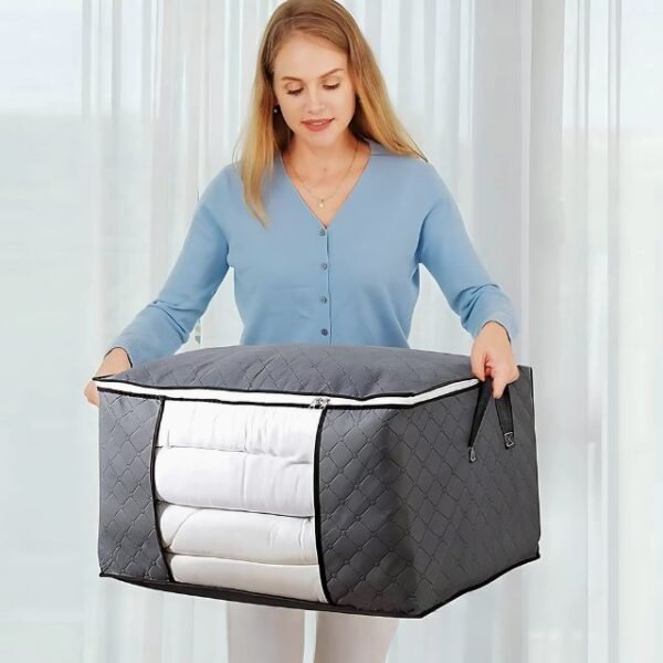 Woman using side handles of foldable storage bag for transport.