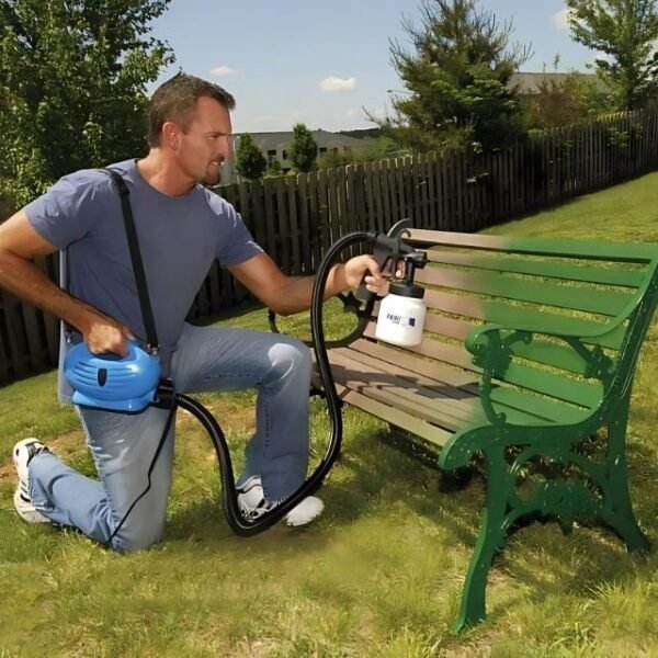 Man renovating a garden bench with Paint Zoom electric spray painter.