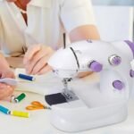 Professional seamstress using portable sewing machine for sewing project.
