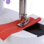 Portable sewing machine stitching through fabric.