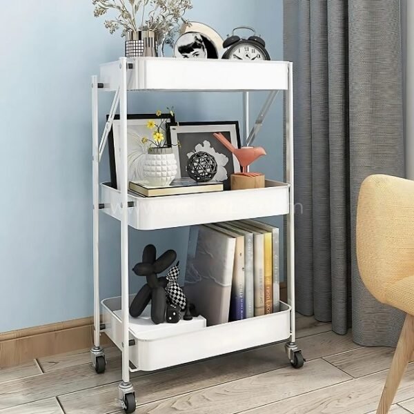 White metal cart holding books, sculptures, and vases, styled as a decorative piece in a living room.