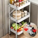 A kitchen cart with three tiers holding jars, containers, and vegetables, featuring close-up of locking wheel for added stability.