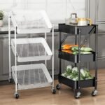 Two storage carts in a kitchen, one black with solid trays holding vegetables and one white with mesh trays, both on wheels for mobility.