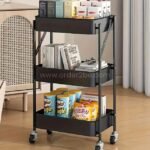 Black cart with tea, books, and snacks on three tiers, ideal for multifunctional home storage.