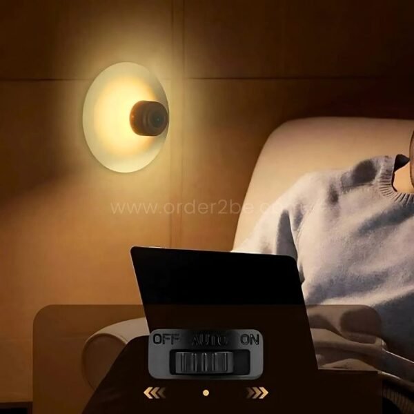 Motion sensor wall lamp glowing beside a person reading.