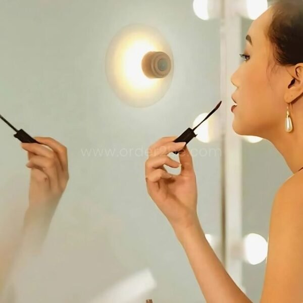 Motion sensor wall lamp providing bright light at a vanity mirror.