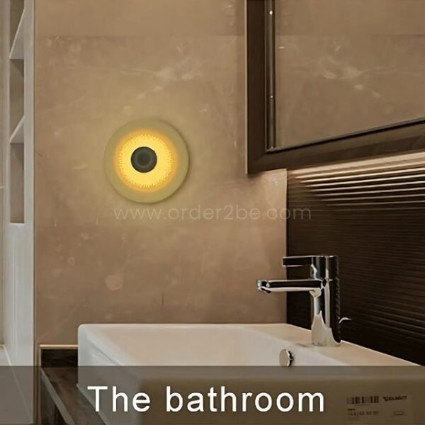 Motion sensor wall lamp mounted above a mirror in a bathroom.