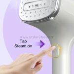 Close-up of a hand pressing the activation button on the portable garment steamer.