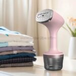Pink portable garment steamer with water reservoir and multi-hole steam plate.