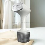 portable garment steamer placed on white surface with beige fabric in front.