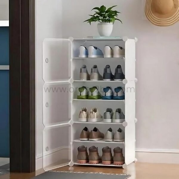 White shoe cabinet with five shelves, open translucent doors, placed by a wall with a hat hanging.