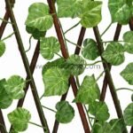Expandable garden fence with green grape leaves, fully extended, made of sturdy wood and realistic plastic leaves, providing privacy and style.
