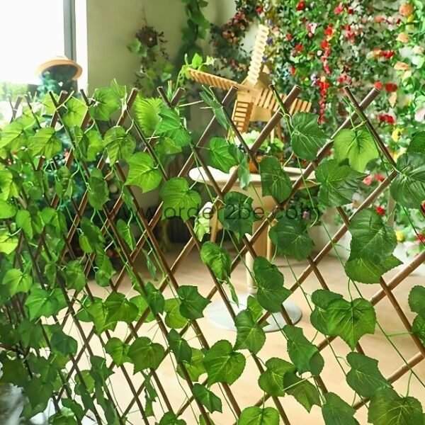 Indoor setup with a green leaf trellis, creating a lush, garden-like atmosphere with plants and wooden decor in the background.