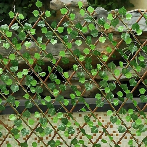 Wooden lattice with green vine plants on a tiled surface, creating a natural, decorative screen with heart-shaped leaves and a mosaic background.