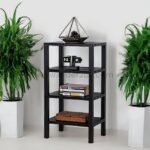 Black 4-shelf organizer stand between white planters, holding a terrarium, books, and decorative items.