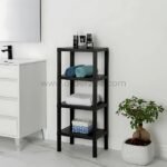 Black 4-shelf organizer stand in a bathroom corner with toiletries, towels, and a polka-dotted storage box.