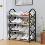 Black metal shoe rack with four shelves organizing shoes in a small entryway.