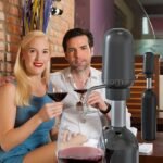 Couple enjoying wine with automatic wine aerator & dispenser pouring red wine into a glass