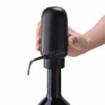 Close-up of hand holding automatic wine aerator & dispenser demonstrating ergonomic design and ease of use