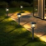A row of solar garden pathway lights along a paved walkway, casting a warm glow for safety and ambiance.