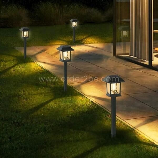 A row of solar garden pathway lights along a paved walkway, casting a warm glow for safety and ambiance.