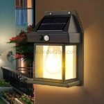Solar-powered wall lamp mounted on an exterior wall with a glowing bulb and solar panel.
