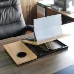 Sleek wooden laptop table with a coffee cup holder on a wooden desk, paired with an office chair and storage cabinet.