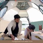 Automatic pop-up camping tent with transparent mesh walls, providing a clear view of the scenic outdoors while offering shelter.