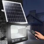GD SUPER 100W solar flood light with remote control, mounted on a wall for outdoor illumination.