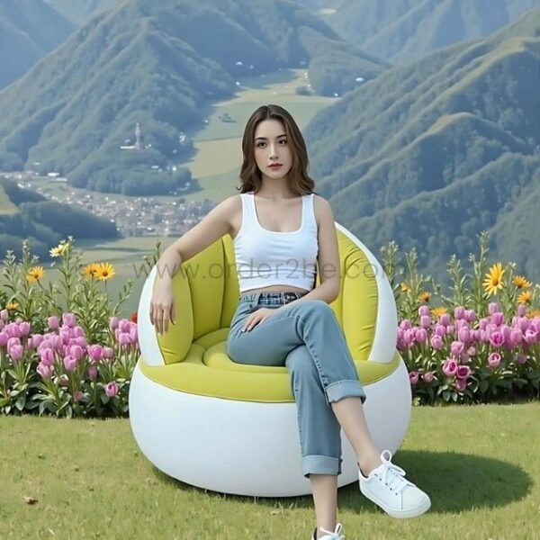 A woman lounging in an inflatable chair surrounded by flowers and mountains.