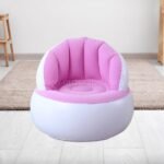 A pink inflatable chair on a wooden floor in a minimalist room.