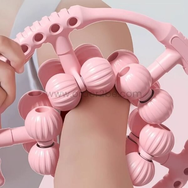 Close-up view of the pink handheld massager showing its detailed design and multiple rollers.