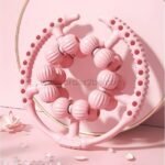 Pink leg massager displayed against a soft pink background, highlighting its sleek and modern design.