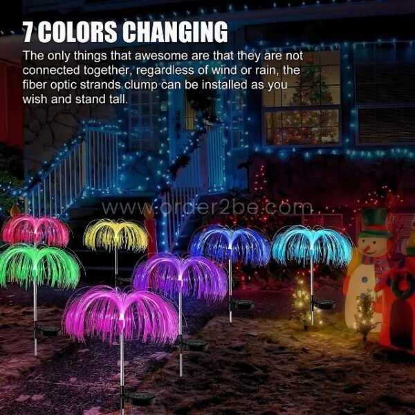 Jellyfish solar garden lights glowing alongside snowmen and twinkly holiday lights in a snowy yard.