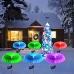 Jellyfish solar garden lights glowing around a snowy Christmas tree, adding festive vibes.