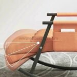 Orange rocking lounge chair with adjustable footrest, highlighting its ergonomic design and customizable comfort features.