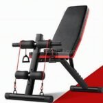 A sleek black and red multi-functional home gym bench with adjustable settings and integrated resistance bands.