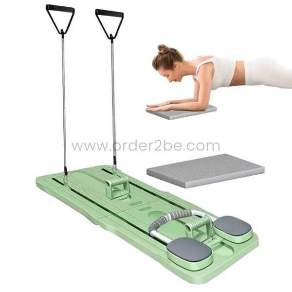 A woman performs a plank exercise on a green multifunctional Pilates exercise board with resistance bands and handles.