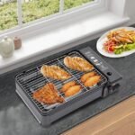 Sizzling chicken breasts cooking on the portable grill placed on a kitchen counter.