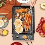 Juicy shrimp and scallops sizzling on the portable grill at an outdoor gathering.