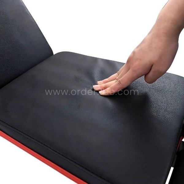 A close-up of the black and red padding on an adjustable full-body workout bench, demonstrating its comfortable texture.