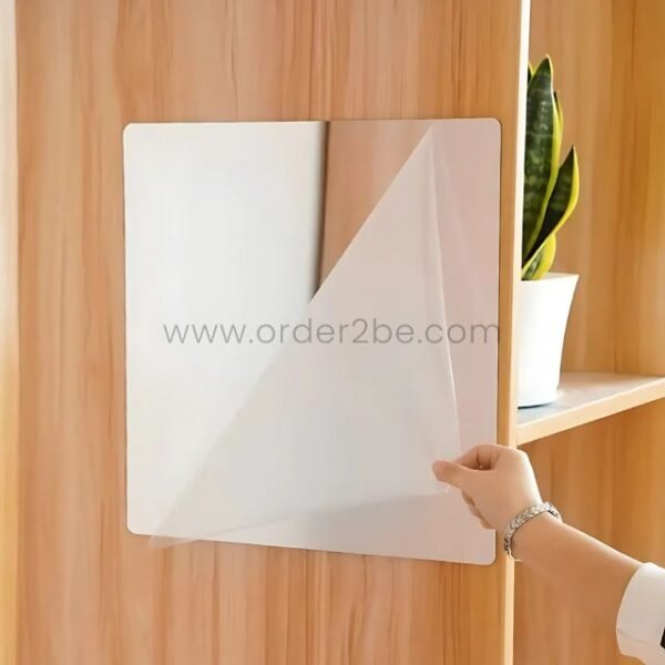 A woman installing 30x30cm self-adhesive mirror tiles on a wooden wall.
