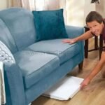 Man folding the tray and sliding it under a sofa.