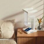 Modern dimmable desk lamp with wireless charging placed on a bedside nightstand.