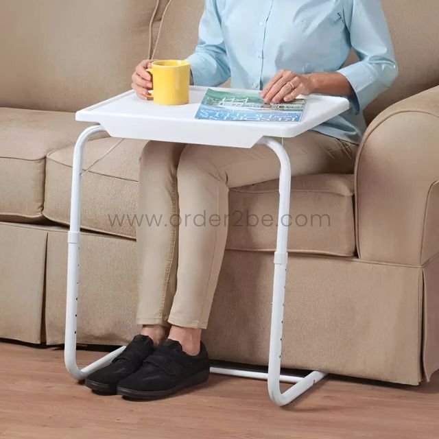 Person lounging with a mug and magazine on the Table Mate Adjustable Tray—couch vibes upgraded.