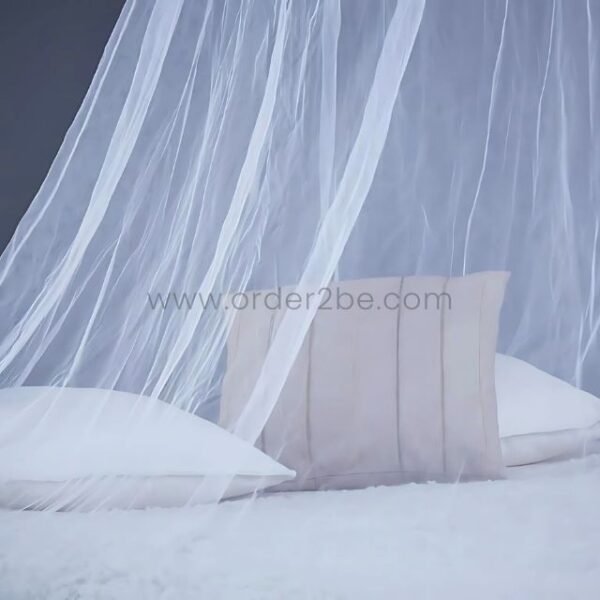 White bed mosquito net gently draped over pillows on a bed, creating a calm, styled setup.