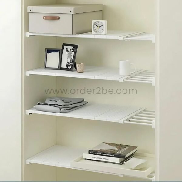 Adjustable Shelf Organizer installed in a living room closet, holding folded clothes and decorative bins.