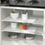 Adjustable Shelf Organizer storing bowls, jars, and kitchen containers inside a cabinet.