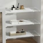 Adjustable Shelf Organizer installed between a bathroom wall and cabinet, holding towels and containers.